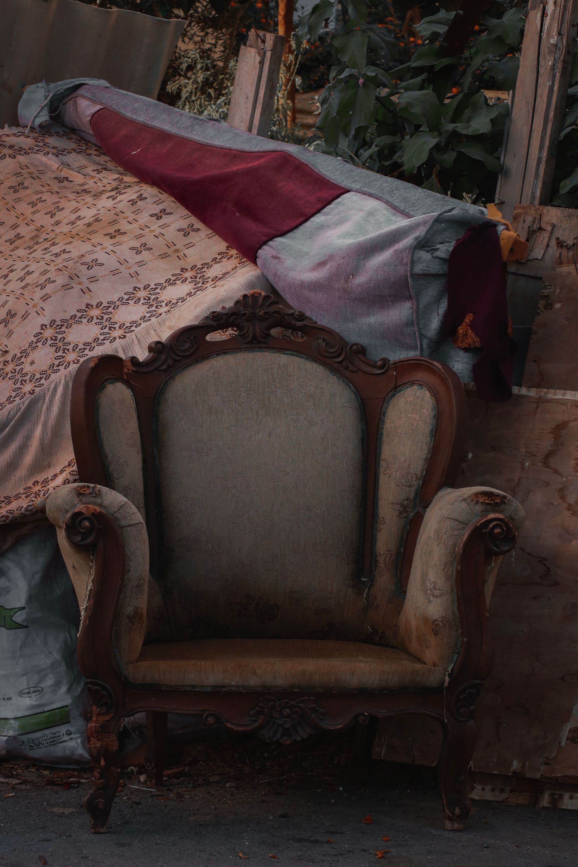 A weathered vintage armchair amidst debris, capturing rustic charm and decay.