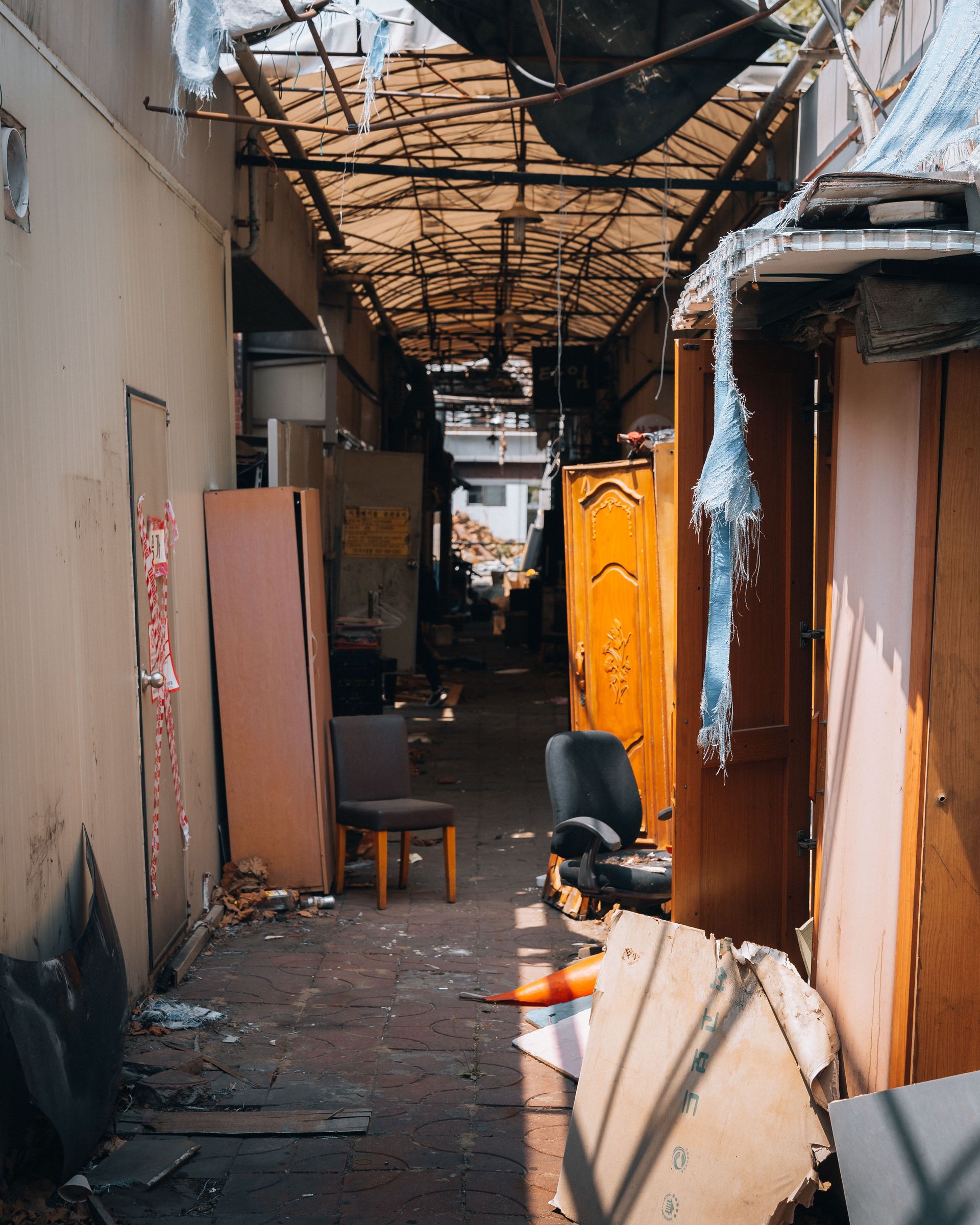 Discover the abandoned alley in Seoul filled with old chairs and wooden cabinets.